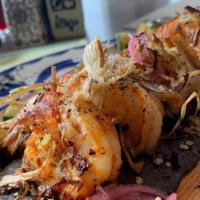 Camarones Zarandeados · Four grilled wild-caught jumbo shrimp with zesty zarandeado sauce, on a bed of black refried...