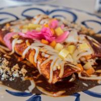 Enchiladas Rojas · Shredded chicken enchiladas, covered with homemade Chile ancho and guajillo sauce. Topped wi...