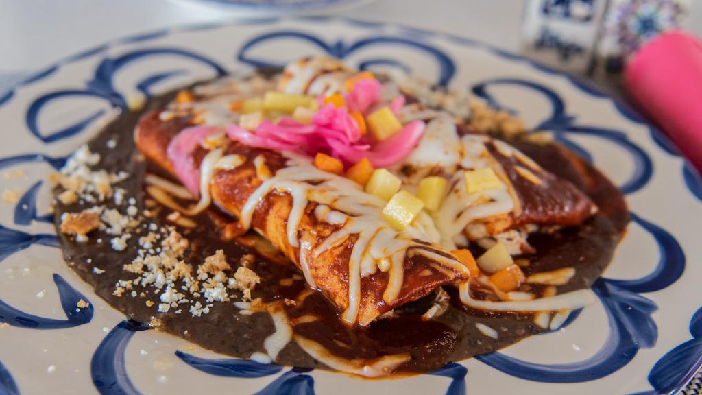 Enchiladas Rojas · Shredded chicken enchiladas, covered with homemade Chile ancho and guajillo sauce. Topped with Oaxaca cheese, sautéed potatoes and carrots and pickled red onions