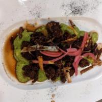 Chicharron De Coliflor · Fried baby Cauliflower on a bed of guacamole, topped with Aji Amarillo and sauté lemongrass
