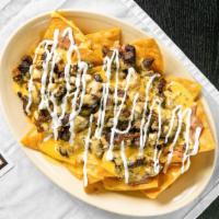 Nachos · Freshly made chips with beans, queso, and your choice of meat.