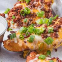 Potato Skins · Baked potato skins, topped with Cheddar cheese, bacon, green onions and served with sour cre...