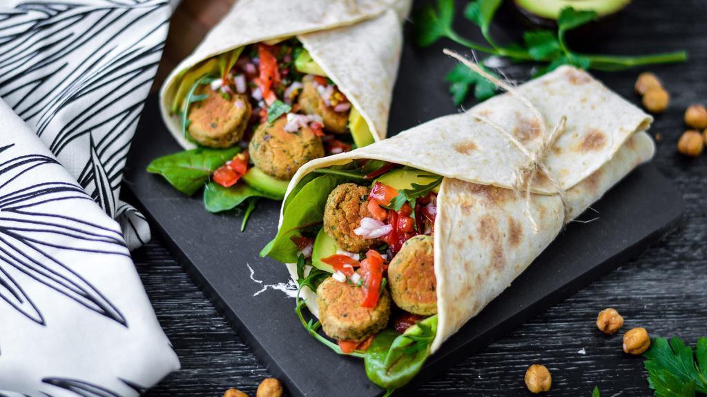 Falafel Wrap · Falafels paired with a delicious Mediterranean salad with nutty tzatziki sauce wrapped in a toasted pita bread.