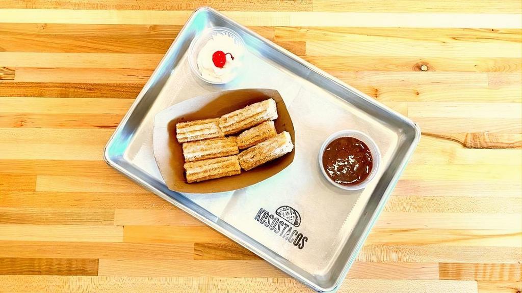 Churro Bites · Six churro bites, tossed in powered sugar, topped with whip cream and a cherry, with a side of homemade chocolate dipping sauce.