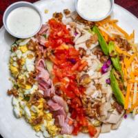 Cobb Salad · Mixed salad greens topped with shredded cheese, tomatoes, avocados, eggs, turkey, ham and ch...
