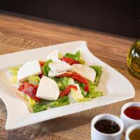 Fresh Mozzarella Salad · Combination of romaine lettuce, fresh mozzarella cheese and red roasted peppers sided with o...