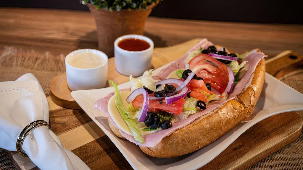 Ham And Cheese Sub · Delicious ham and provolone cheese with roasted peppers, romaine lettuce, red onions, tomatoes, black olives and provolone cheese along with red tomato vinaigrette house dressing.