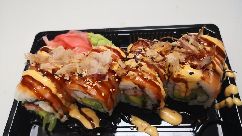 Yammy Yammy Roll · Imitation crab, avocado, cucumber,  wrapped with salmon on top, Drizzled with eel sauce, spicy mayo, and bonito flakes.