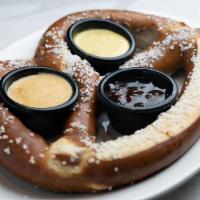 Oven Baked Soft Pretzel · One freshly baked jumbo pretzel, buttered and salted. Served with a Jalapeño Jam, Sweet Must...