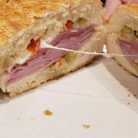 Muffuletta · Our signature crusty bread, smothered with marinated olive salad, cured ham, Italian salami,...