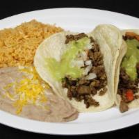 Carne Asada Tacos (2) · On top of tacos is pico de gallo, guacamole, and rice and beans on the side.