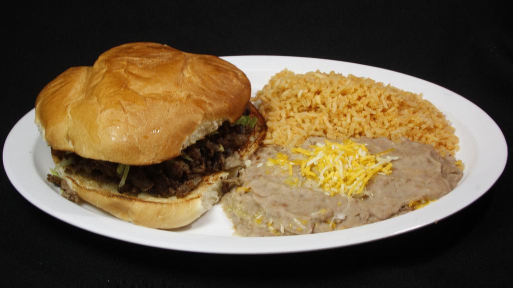 Torta Plate · Carne asada torta with guacamole and lettuce inside the torta and rice and beans on the side.