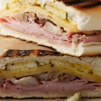 Sándwich Cubano · incluye jamón , carne de cerdo, queso ,salami, pepino encurtido y salsas