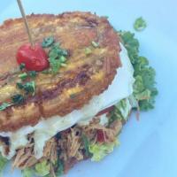 Patacon · Shredded Beef or Chicken over Fried Plantain, Ham & Cheese, Avocado, covered with Shredded C...