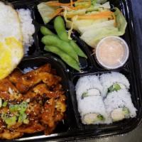 Chicken Teriyaki Bento · Chicken teriyaki dish with a side of salad, edamame, miso soup, steamed rice topped with an ...