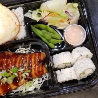 Grilled Salmon Bento · Grilled salmon dish with a side of salad, edamame, miso soup, steamed rice topped with eel s...