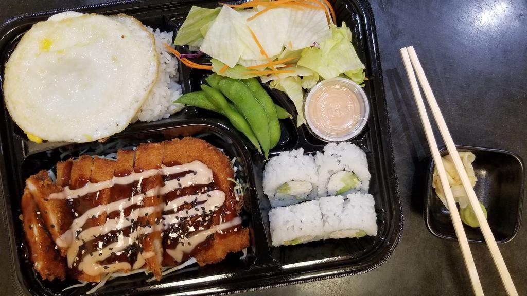 Chicken Cutlet Bento · Chicken cutlet dish with barbecue sauce and a side of salad, edamame, miso soup, steamed rice topped with an egg, and 4 pieces of California roll.
