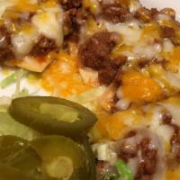 Nachos Supremo · Picadillo or ranchera chicken with refried beans and cheese.