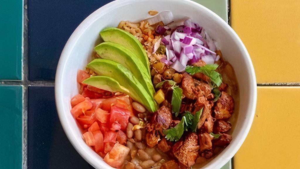 Al Pastor Bowl · Gluten-free. Pineapple-marinated pork over Mexican rice, topped with charro beans, diced tomatoes, onions, avocado slices, and a lime wedge – served with our Amores sauce.