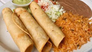 Flautas De Pollo · Three chicken flautas on a bed of lettuce and tomato. Served with tomatillo and avocado sauc...