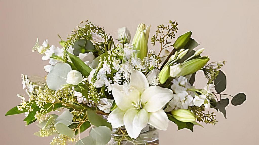 Alluring Elegance Bouquet · A monochromatic creme & white floral arrangement designed with seasonal blooms and sprigs of foliage in a 6