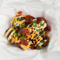 Naughty Tots · Home-made tater tots stuffed with Cheese topped with bacon and drizzled jalapeno ranch.
