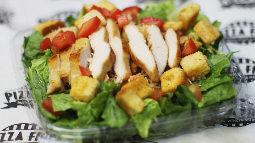 Grilled Chicken Caesar · Crispy romaine lettuce, tomatoes, croutons, Parmesan cheese, and chicken.