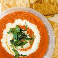 Chips N Salsa Roja · Chile de árbol salsa, Mild heat, topped with table cream and cilantro 8oz
