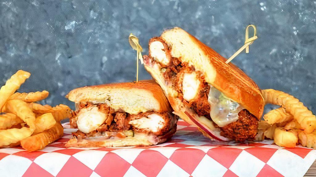 Nashville Po'Boy · Crispy Nashville hot chicken tenders pressed in a French roll with Monterey jack cheese, dill pickles, red onions, and our signature brown mustard sauce.