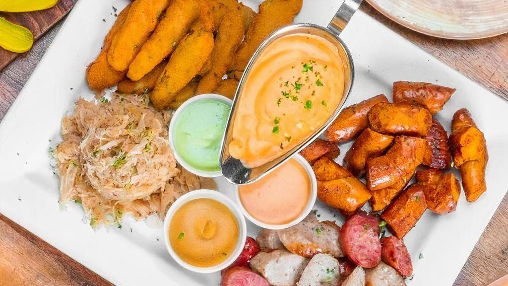 American Sampler · A tasty journey that consists of Pretzel Bites, Bavarian Fried Pickles ,Sliced Polish and Grilled Bratwurst sausages, Sauerkraut, Cheddar Bacon Bier Sauce, Spicy Aioli, Avocado-Cilantro Ranch, and King’s Mustard