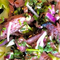Nam Tok (Beef Salad) · Grilled marinated beef tossed with red onion, scallion, fresh mint, cilantro, lime juice, an...