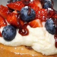Very Berry Roll* · crème brûlée frosting topped with fresh strawberries, blueberries, raspberry jam and powdere...