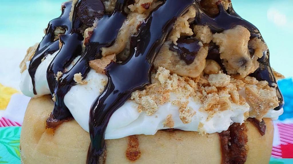 Cookie Dough Cheesecake Roll* · cheesecake frosting topped with homemade chocolate chip cookie dough, graham cookies and chocolate sauce.