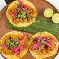 Cochinita Pibil · Slow roasted pork shoulder braised in achiote paste with red pickled onions.