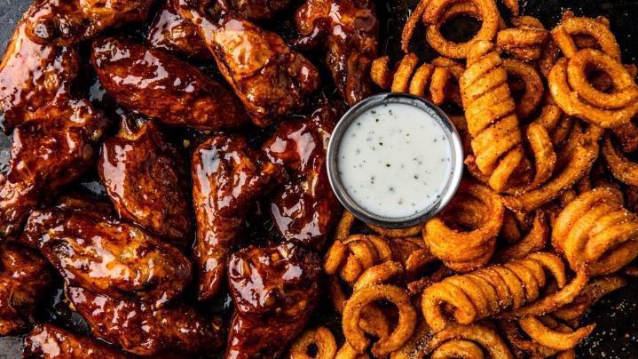 16 Bone-In Wings · 16 bone-in wings tossed in your choice of 2 flavors. Served with curly fries & a side of ranch.