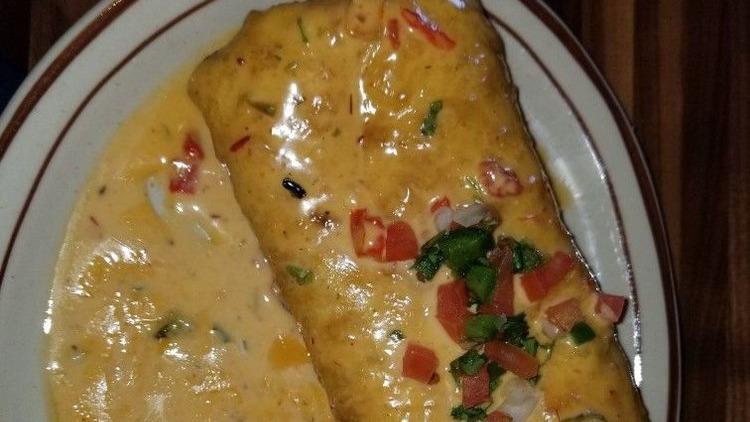 El Patio Chimichanga · Large flour tortilla stuffed with mixed cheese, pico de gallo, and your choice of smoked brisket or pollo rostisado. Lightly fried and then topped with Texas queso. Served with your choice of side.