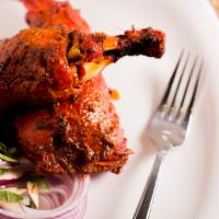 Tandoori Chicken (Half) · Grilled bone-in chicken marinated in yogurt, garlic, ginger & fresh ground spices.