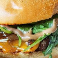 *The Grind · Beef patty served on a Brioche bun w/ aged Cheddar cheese, grilled onion, greens and black g...