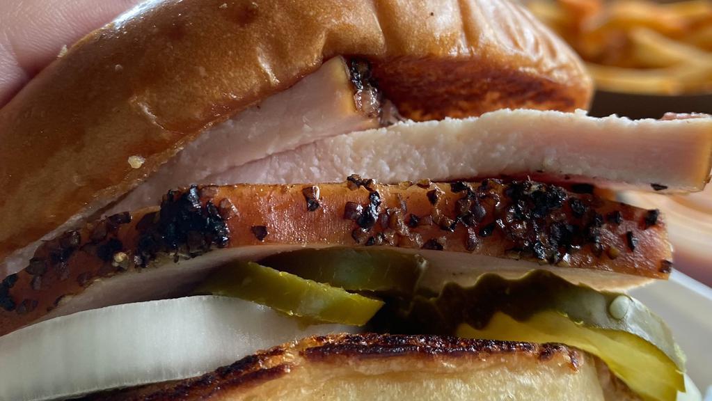 Smoked Turkey Sandwich · Slow smoked turkey between butter griddled buns. pickles onions and sauce served on the side.