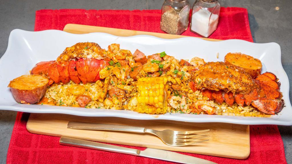 Stuffed Lobster Tails W/Loaded Rice · 2 Seasoned grilled lobster tails stuffed with cajun fried rice and loaded with grilled shrimp, chicken, and sausage.  With 1 corn and 1 potato.