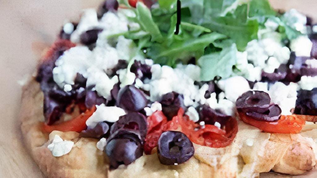 Caspian Flat Bread · Crispy flat bread layered with Caspian seasonings, zatar seasonings, sesame seeds, Mediterranean blend cheese, feta cheese, tomatoes and onions, black olives, topped with tzatziki and tomato sauce. Add gyro meat for an additional charge.