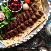 Kabob Koobideh & Bread · 2 skewers of juicy ground beef kabobs served over bread, with sides of onions and grilled to...