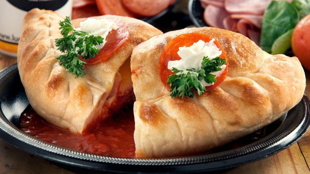 Meat Calzone · Baked calzone stuffed with ham, pepperoni, ricotta, and mozzarella cheese.
