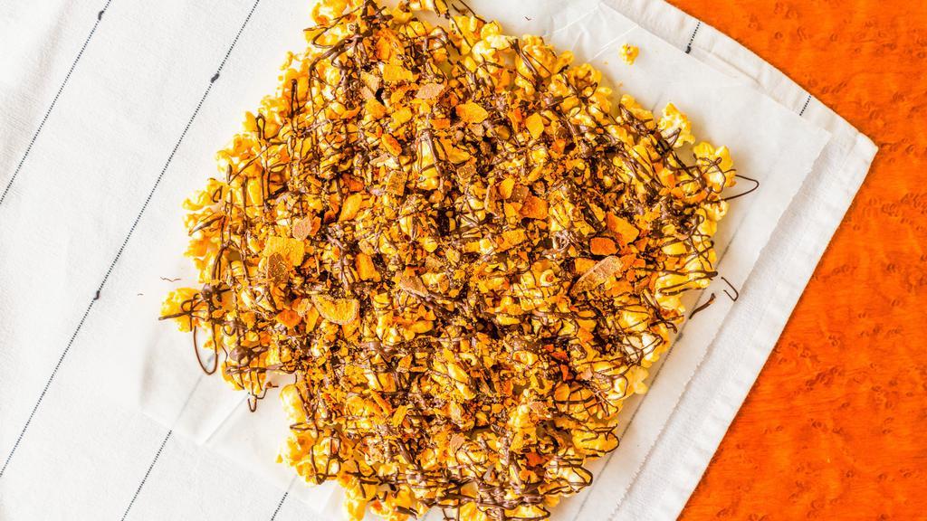 Butterfinger Crunch Popcorn · Sweet crunchy caramel popcorn drizzled in creamy milk chocolate and Butterfinger candy pieces.