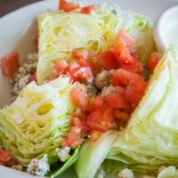 Wedge With Bleu Salad · Crisp iceberg lettuce with crumbled bleu cheese and chopped ripe tomatoes, drizzled with ble...