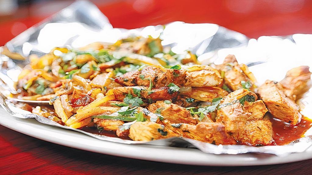 Tawa Chicken · Strips of marinated chicken sautéed in a tawa with onions, tomatoes, coriander, jalapeños, and ginger.