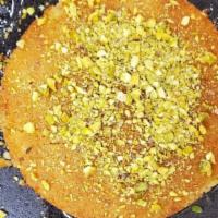 Kunafa With Cheese · Ground phyllo dough with a layer of creamy sweet cheese, topped with nuts and sugar syrup.