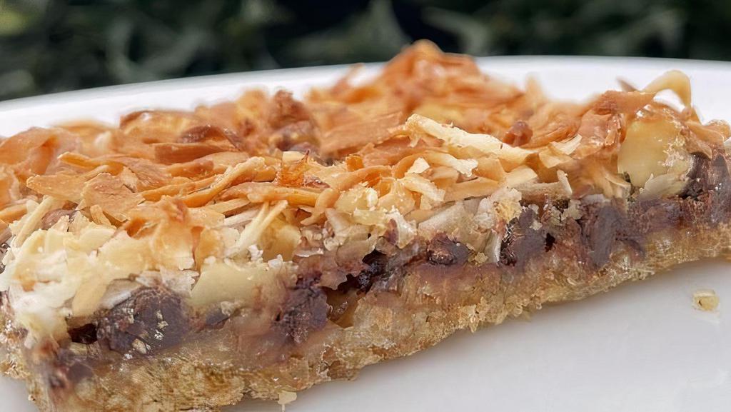 Magic Cookie Bars* · a rich layered cookie bar with graham cracker crust, plant based sweetened condensed soy milk, chocolate chips, walnuts and coconut toasted to perfection