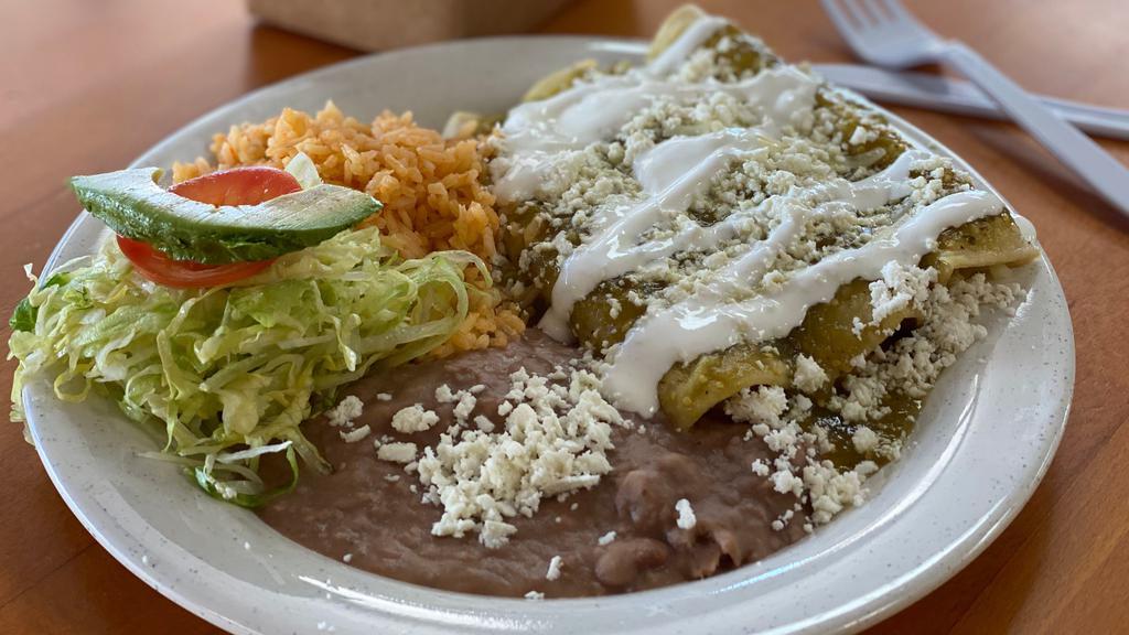 Enchilada Plate · Your choice between: Chicken or Cheese with Green Tomatillo Salsa, topped with Queso Fresco & Sour Cream—with Rice, Beans & Side Salad
