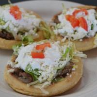 Sopes · Sopes topped with beans, choice of meat, lettuce, sour cream, and sliced tomatoes.
